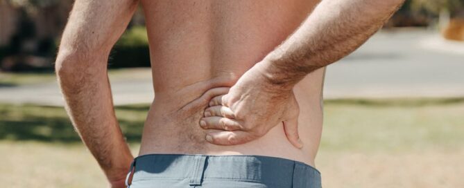 Man holding lower back in pain