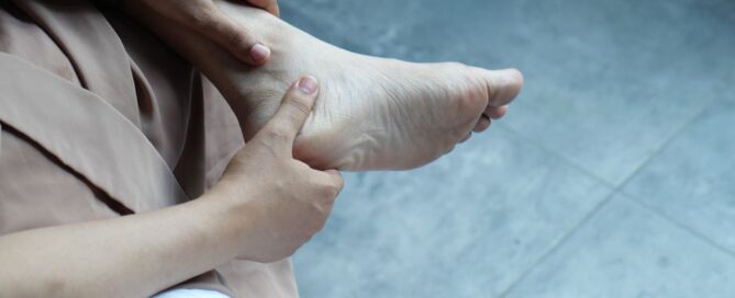 Woman massaging foot with plantar fasciitis pain